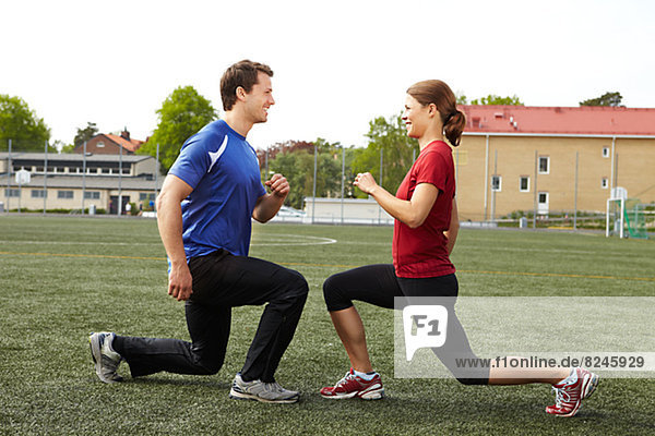 Female and male athletes exercising on field