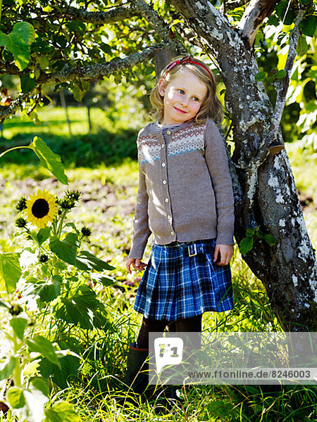 Girl leaning against apple tree