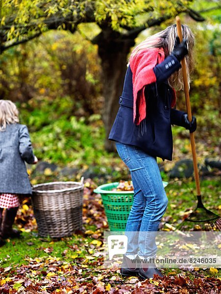 Woman and girl raking leaves