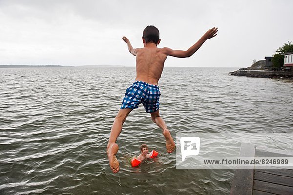 Boy jumping into water