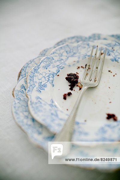Detail of a fork and crumbs of a chocolate cake.