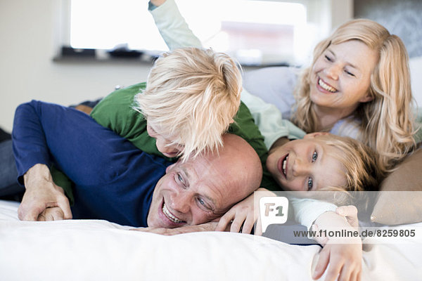 Portrait of happy boy with family in bed