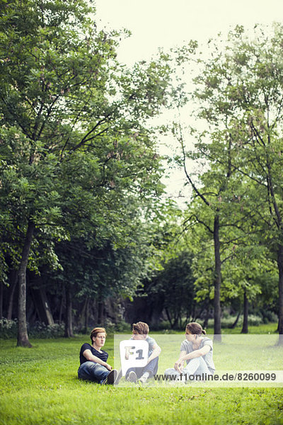 Young male friends relaxing on grass at park