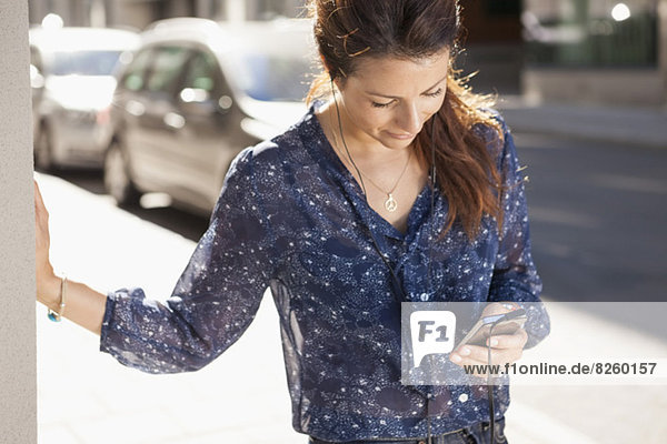 Geschäftsfrau mit Handy auf der Straße