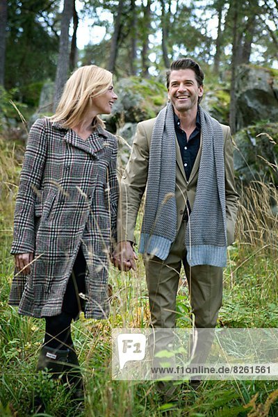 Smiling mature couple walking through forest