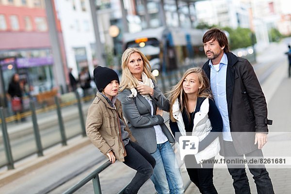 Family with two kids waiting for tram