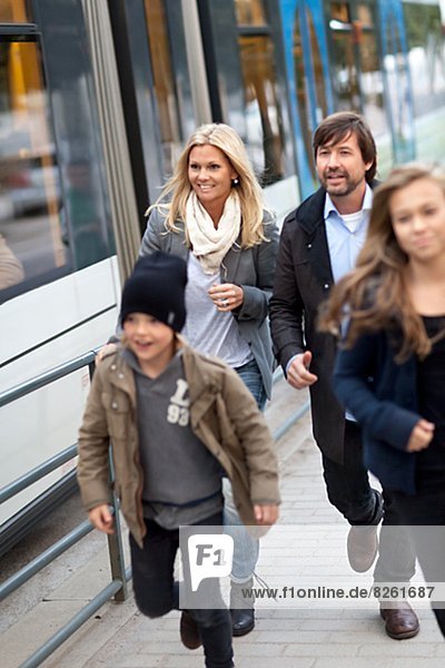 Family with two kids boarding on tram