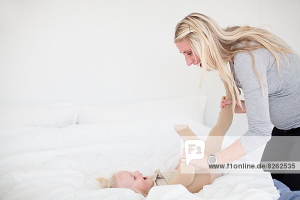 Mother playing with Daughter im Bett
