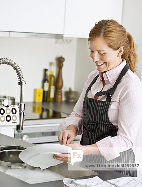 Frau lächeln waschen Essgeschirr