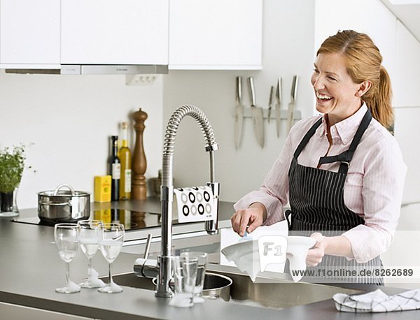 Frau lächeln waschen Essgeschirr
