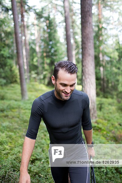 Mid adult man walking through forest