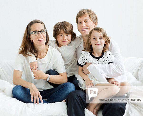 Happy family sitting on sofa  studio shot