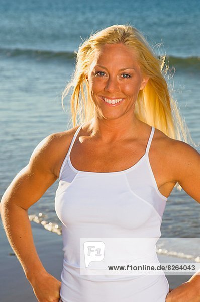 A blond woman working out on a beach  Portugal.