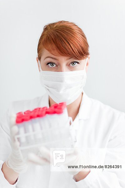 Female scientist in laboratory holding test tubes