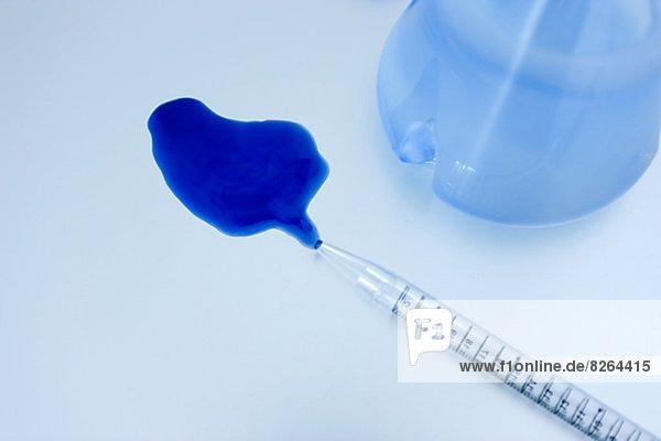 Pipette with spilled blue liquid  studio shot