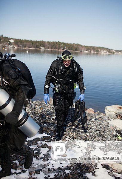 Two divers walking out of water