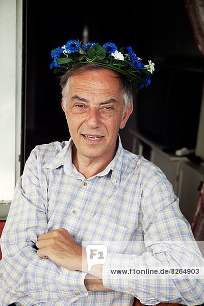 Senior man wearing midsummer wreath