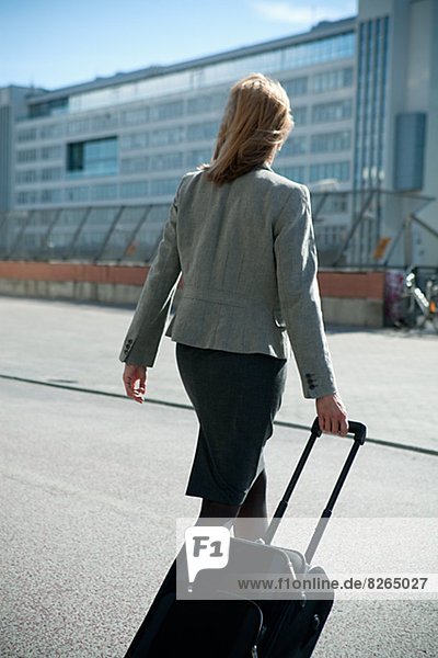 Businesswoman walking with suitcase