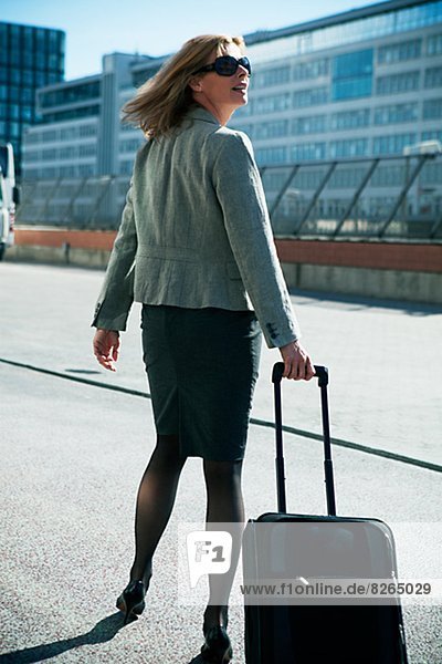 Businesswoman walking with suitcase