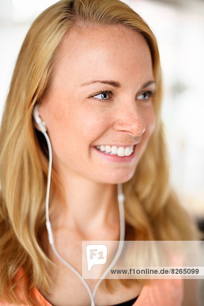 Smiling young woman listening music