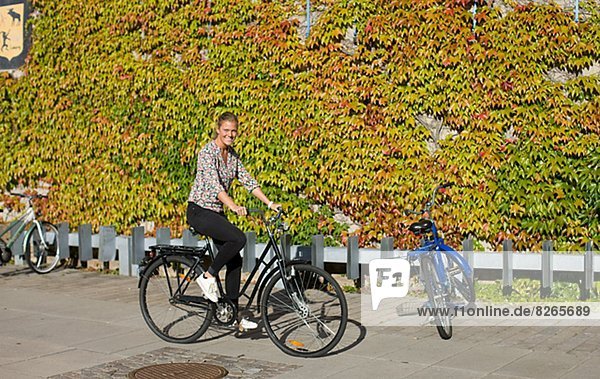 Smiling university student cycling