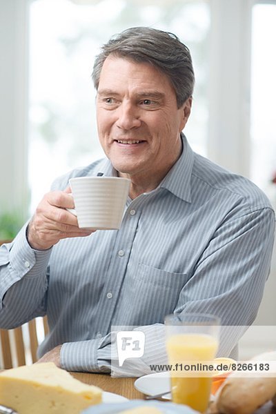 Mann  lächeln  reifer Erwachsene  reife Erwachsene  essen  essend  isst  Frühstück