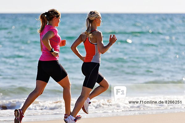 Young women running on beach  Algarve  Portugal
