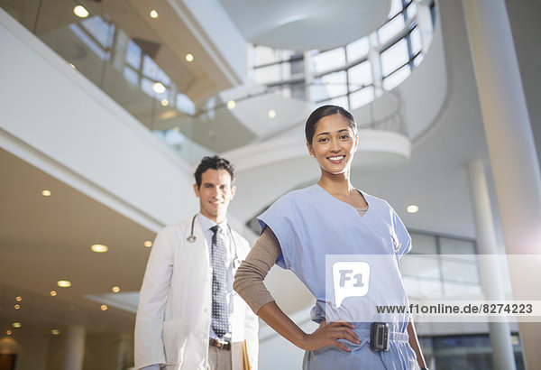 Porträt des lächelnden Arztes und der Krankenschwester im Krankenhausatrium