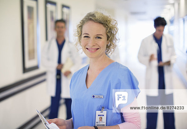 Portrait of smiling nurse in hospital corridor