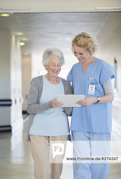 Krankenschwester und alternder Patient im Krankenhausflur