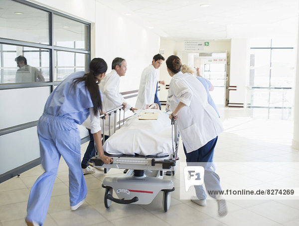 Ärzte hetzen Patienten auf Bahre den Krankenhausflur hinunter