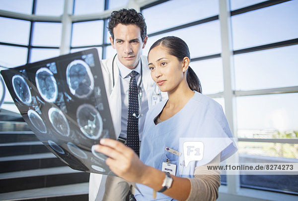 Arzt und Krankenschwester sehen Kopf-Röntgenbilder auf der Treppe des Krankenhauses