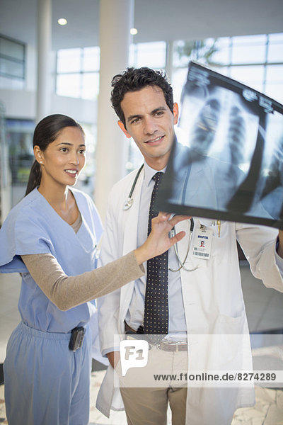 Arzt- und Krankenschwesterbetrachtungskopf-Röntgenaufnahmen
