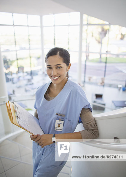 Porträt der lächelnden Krankenschwester auf der Krankenhaustreppe