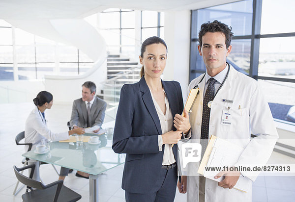 Portrait of confident doctor and businesswoman in meeting