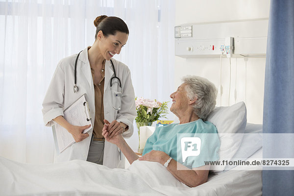 Doctor and senior patient talking in hospital room