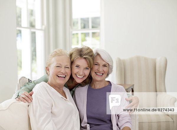 Porträt von lächelnden Seniorinnen im Wohnzimmer