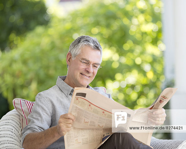 Senior Mann liest Zeitung auf der Terrasse