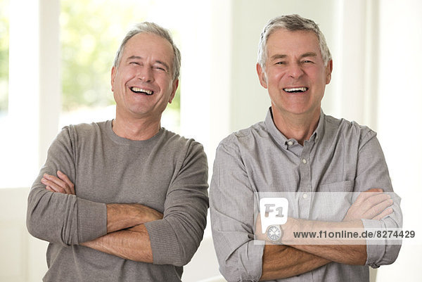 Portrait of senior men laughing with arms crossed