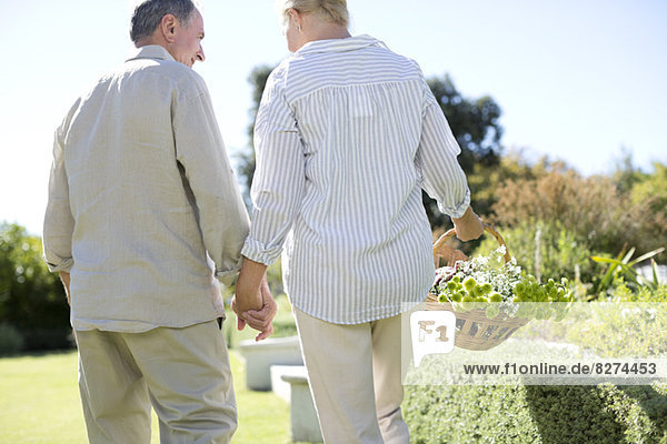 Seniorenpaar hält Händchen im Garten