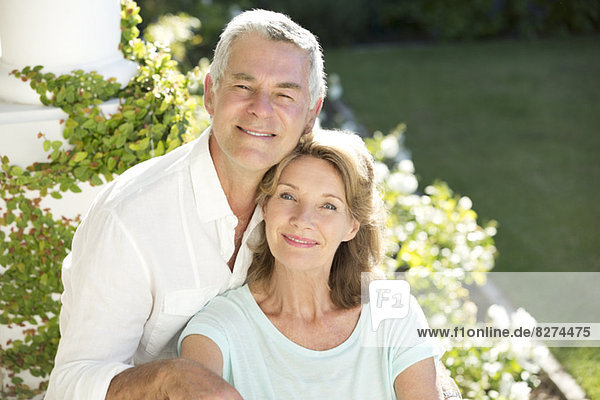 Porträt eines lächelnden Seniorenpaares im Garten