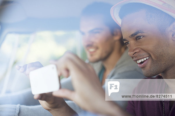Männer mit Fotohandy im Auto
