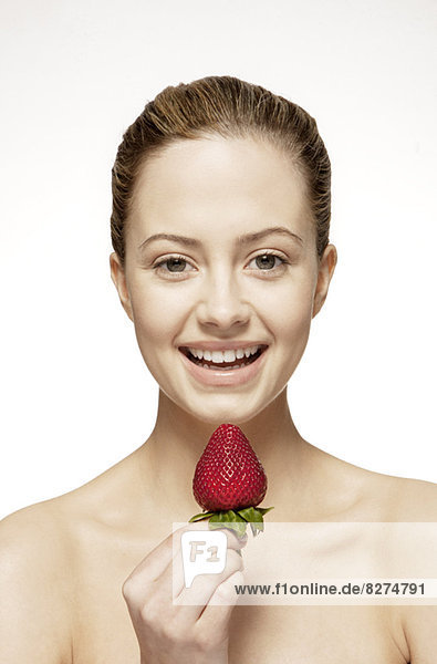 Lächelnde Frau isst Erdbeere