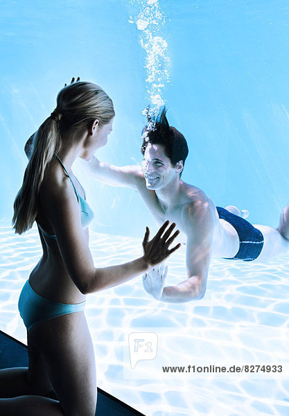 Woman at window smiling at man underwater