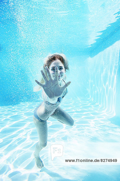 Porträt der lächelnden Frau unter Wasser im Schwimmbad