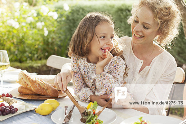 Mother and daughter eating in garden