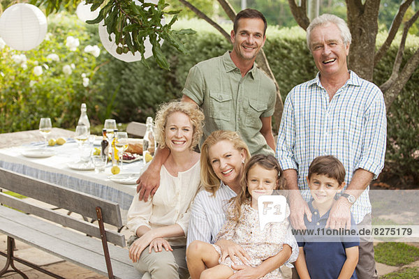 Portrait of smiling multi-generation family at table in garden