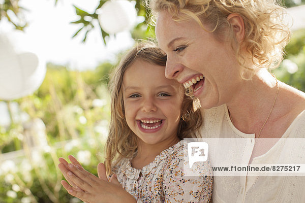 Mother and daughter laughing outdoors