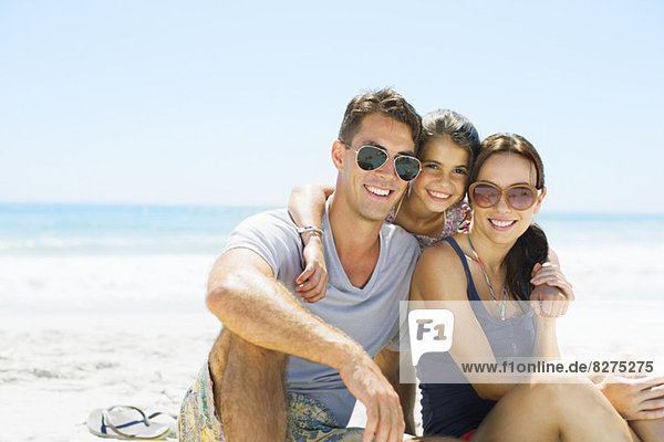 Portrait of smiling family hugging on beach