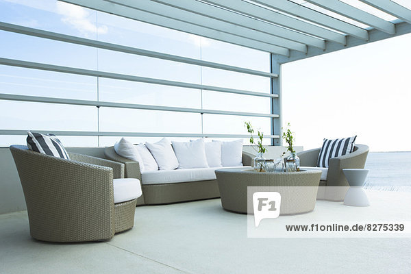 Sofa und Stühle auf moderner Terrasse